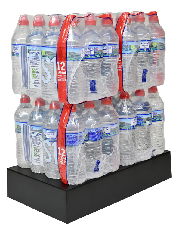 Supermarket plinth supporting packs of large water bottles